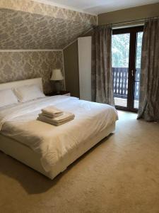 a bedroom with a bed with towels on it at Platinvm B&B in Predeal