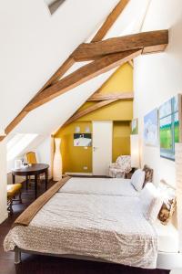 1 dormitorio con 1 cama grande en el ático en Hotel Het Wethuys, en Watou