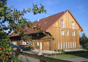 ein großes Holzhaus mit einem davor geparkt in der Unterkunft Gästehaus am Sonnenfeld in Sommeri