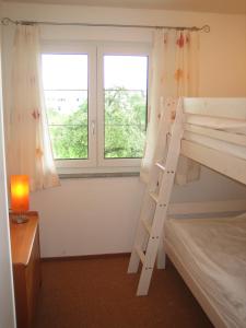 a bedroom with two bunk beds and a window at Gästehaus am Sonnenfeld in Sommeri