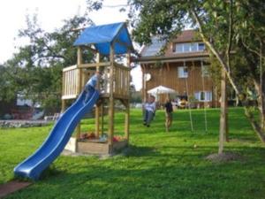 einen Spielplatz mit einer blauen Rutsche im Hof in der Unterkunft Gästehaus am Sonnenfeld in Sommeri