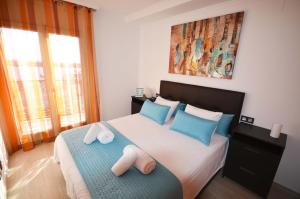 a bedroom with a bed with blue and white pillows at La Torre Oceanside in Cambrils