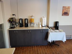 a kitchen with a counter with a table with a coffee maker at Travelodge by Wyndham Baie Comeau in Baie-Comeau +12 photos