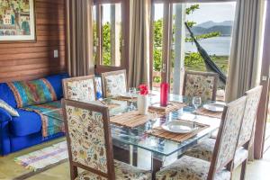 a dining room with a table and chairs and a couch at Casa em CondomÍnio Fechado com Vista para Lagoa in Garopaba