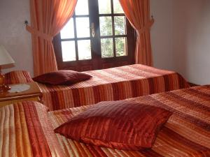 two beds in a room with a window at Casa Los Viñedos B in Fuencaliente de la Palma