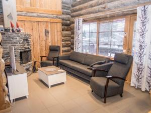 a living room with a couch and chairs and a fireplace at Holiday Home Mäentähti a by Interhome in Ruka