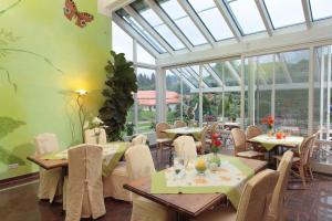 a restaurant with tables and chairs in a room with windows at TOP-FeWo,Südterrasse,Wellness,Saunanutzung in Wertach