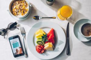 a table with a plate of fruit and a cup of coffee at Iberostar Selection Lagos Algarve in Lagos