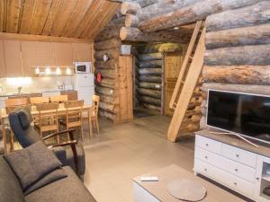 a living room with a couch and a dining room at Holiday Home Mäentähti a by Interhome in Ruka