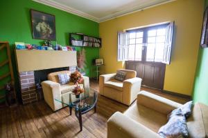 a living room with green walls and a fireplace at Hospedaje Turistico Recoleta in Cusco