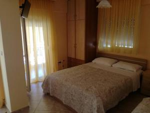 a bedroom with a bed and a large window at Litsa 1 in Metamorfosi