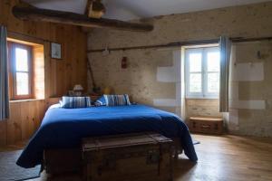 1 Schlafzimmer mit einem blauen Bett und 2 Fenstern in der Unterkunft Domaine TerrOcéane in La-Gripperie-Saint-Symphorien