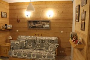 1 dormitorio con 1 cama en una pared de madera en L'Enclave, en Les Contamines-Montjoie