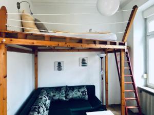 a bunk bed in a room with a couch and a ladder at Apartment Molea in Freiburg im Breisgau