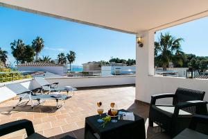 a patio with chairs and tables on a balcony at Villa Baladres in Alcudia