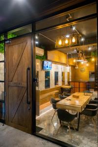 a dining room with a wooden door and a table at Comfy Bed Hostel in Bangkok