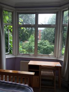 a room with a window with a desk and a table at 38 Whitehall Road in Harrow on the Hill