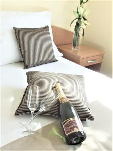 a bottle of champagne and a glass on a bed at Hotel Central Slavonski Brod in Slavonski Brod