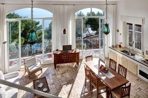 a kitchen and dining room with a table and chairs at Morso di luna in Nerano