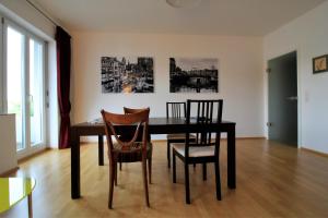 a dining room with a black table and chairs at Luxury city apartment - view of river and castle in Würzburg