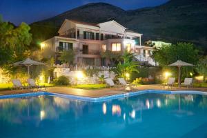 a house with a swimming pool at night at Fotini in Ayia Evfimia