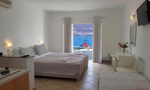1 dormitorio con cama y ventana con vistas en Paros Paradise Apartments, en Parikia