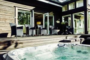 a jacuzzi tub on a porch with chairs at Merenranta Huvila 210 m2 in Kokkola