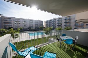 balcón con mesa y sillas y piscina en LOVELY NEW APARTMENT 5 Min WALK TRAIN STATION 7 Min TO CALAFELL BEACH en Calafell