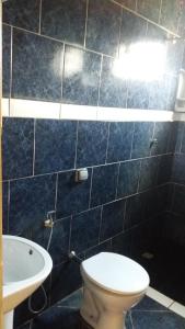 Un baño con azulejos azules, inodoro y lavabo. en Casa da Mary, en Pirenópolis 29 fotos más