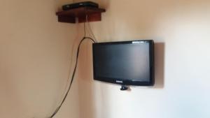 una pequeña televisión colgada en una pared en Casa da Mary, en Pirenópolis