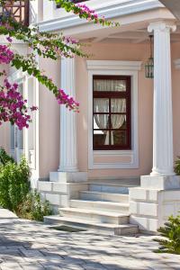 a house with white columns and a door at Veggera Beach Hotel in Perissa