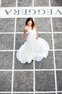 a woman in a white dress walking on the street at Veggera Beach Hotel in Perissa