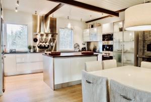 a kitchen with white cabinets and a table with chairs at Merenranta Huvila 210 m2 in Kokkola
