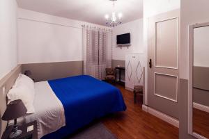 een slaapkamer met een bed met een blauwe deken bij Villa dei Pescatori in LʼAquila