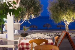 a table with wine glasses on it with a view of the ocean at Veggera Beach Hotel in Perissa