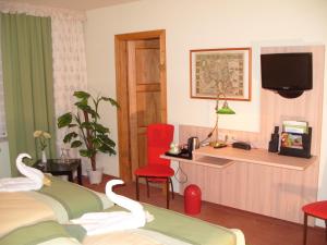 a hotel room with two beds and a desk at Hotel Haufe in Forst