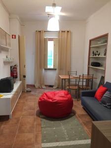 a living room with a red bean bag on the floor at Gast House in Faro