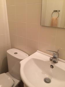 a bathroom with a white toilet and a sink at Gast House in Faro