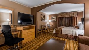 Best Western Marquis Inn & Suites في برينس ألبرت: غرفة فندقية بسرير وتلفزيون بشاشة مسطحة