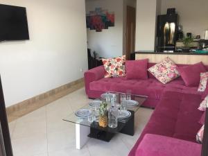 a living room with a purple couch and a table at Villa Catalpas in Taroudant