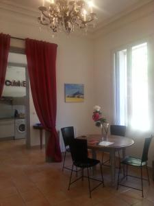 a dining room with a table and a red curtain at Le jardin de Saint Just in Narbonne