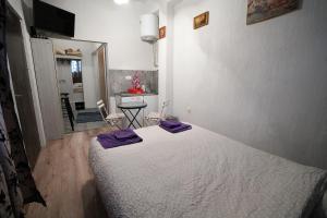 a bedroom with a bed with purple pillows on it at Apartman Rale in Belgrade