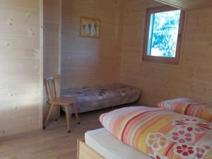 una camera con un letto e una sedia in una cabina di Berghütte Plafötschalm a Tires