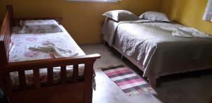 a bedroom with two twin beds and a rug at Condomínio Canaã Cumuruxatiba in Cumuruxatiba