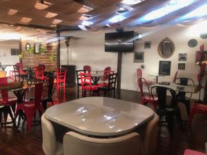 um restaurante com cadeiras vermelhas e mesas num quarto em Hotel Barba Lá em Combarbalá