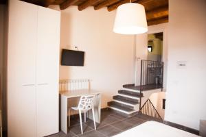 una sala da pranzo con un tavolo e una televisione di San Giorgio Rooms a Caltagirone