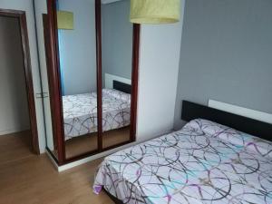 a bedroom with a bed and a dresser with a mirror at Piso para grupos en Logroño in Logroño