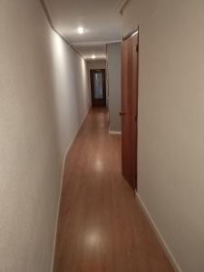 un pasillo vacío con suelo de madera y puerta en Piso para grupos en Logroño en Logroño