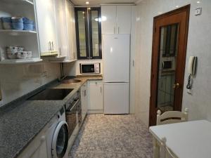 a kitchen with a white refrigerator and a sink at Piso para grupos en Logroño in Logroño