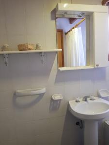 a white bathroom with a sink and a mirror at Nahuel Mapi Lodge in Pilolil +71 photos